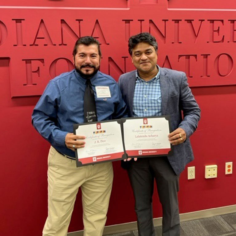two men hold certificates