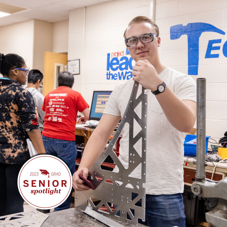 A man poses with a robot.