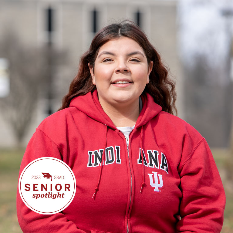 A woman poses for a picture in a red IU sweatshirt.