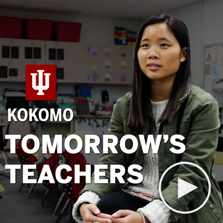 A woman sits in an elementary classroom.