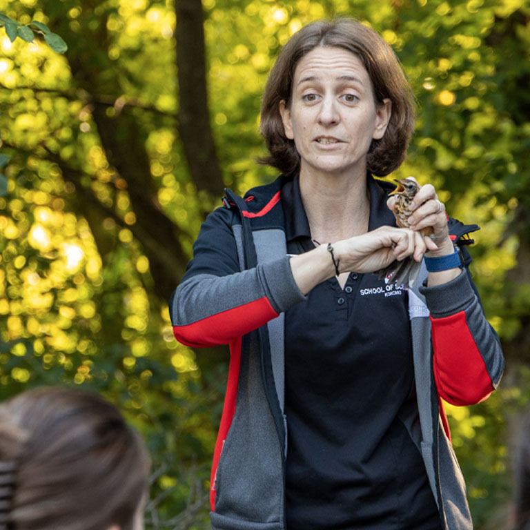 A woman holds a bird
