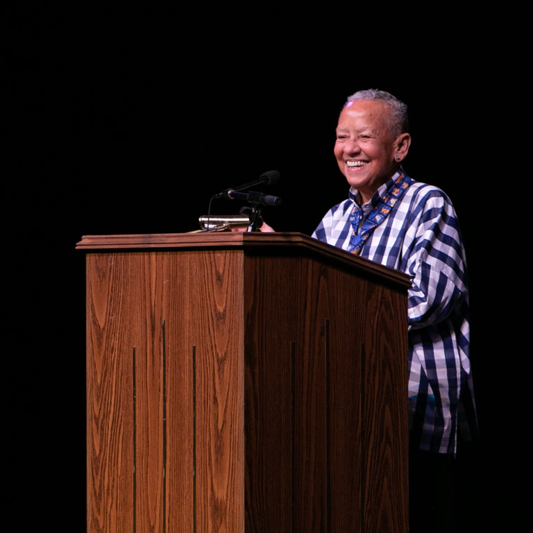 A smiling woman stands at a podium