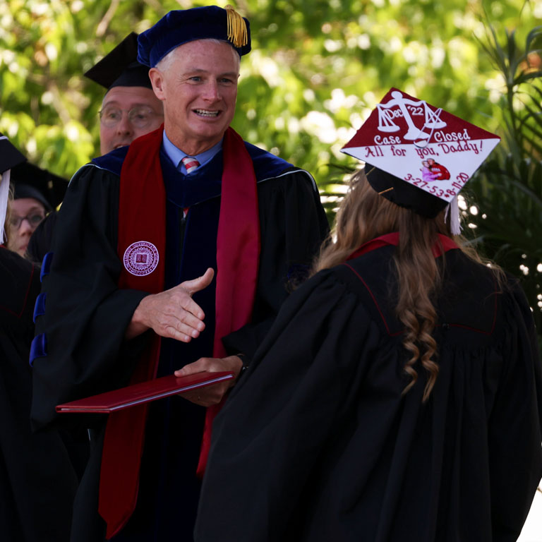 Two people in academic garb at Commencement