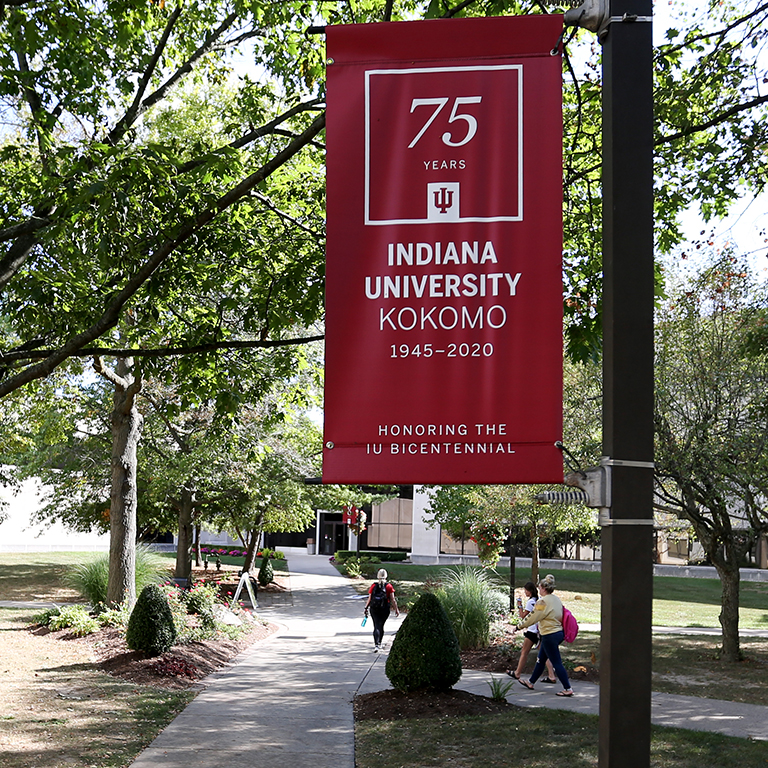 A red IU bicentennial banner in the quad