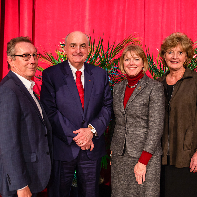 Two men and two women against a red background