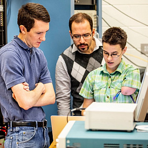 Pettus and Elise Novitski --the other lead author of Project 8's recent publication--discuss in front of the apparatus at the University ...