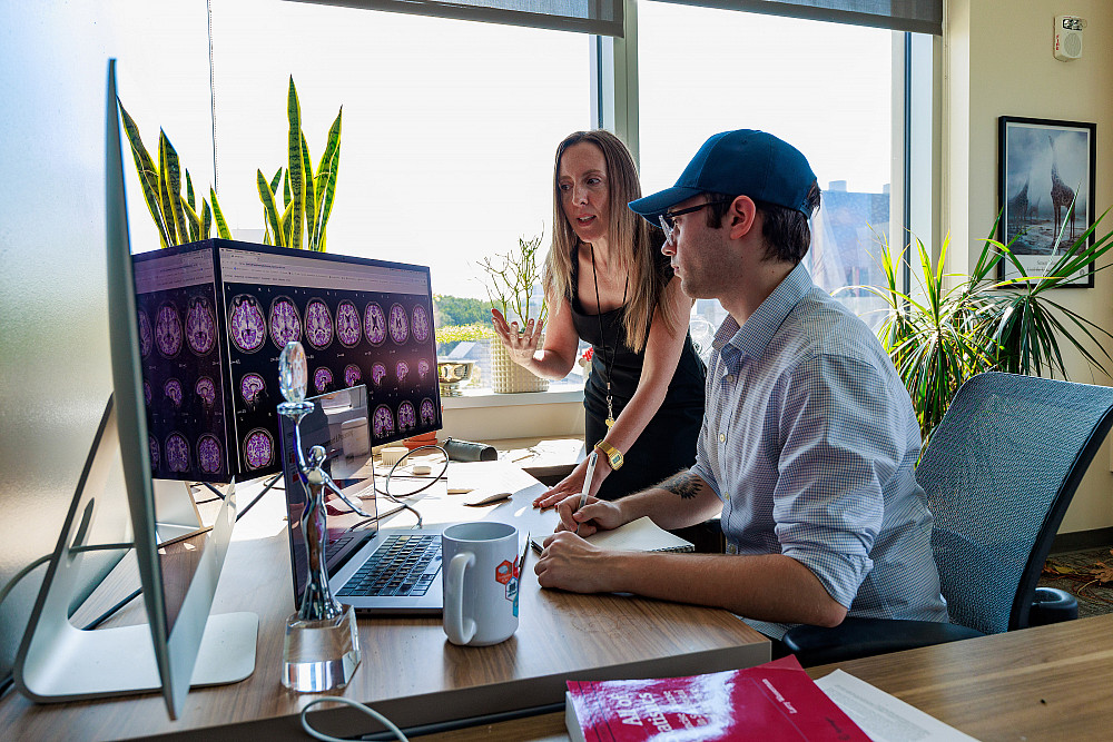 Amanda Mejia and student Garrett Collier review the results of fMRI scans on a computer.
