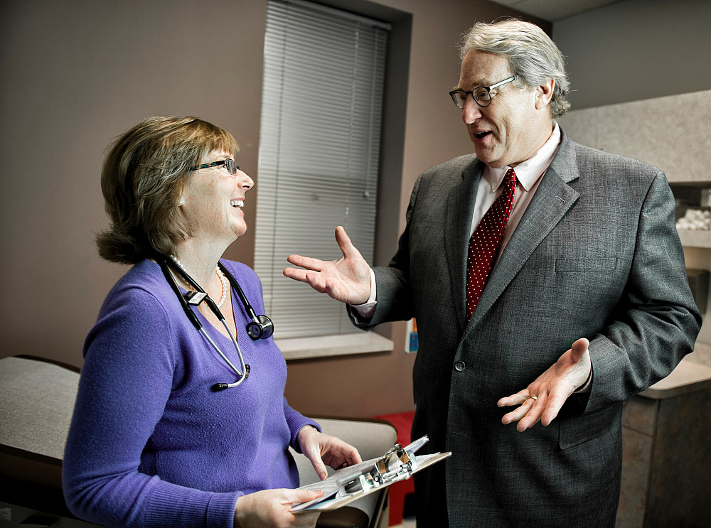 A physician speaks with a professor