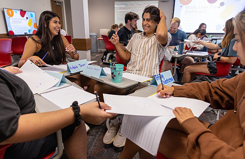 Victoria Torres, left and Hudson Pangan react as they are tasked with drawing portraits of fellow classmates during the Walter Center