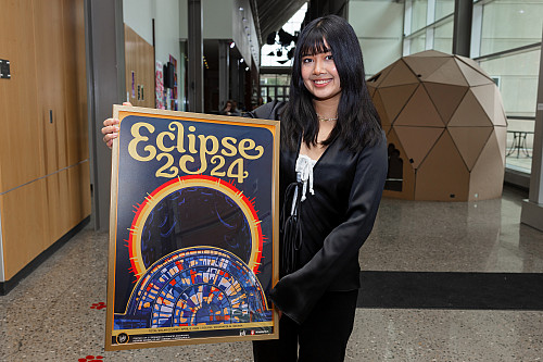 Frances Dimaranan holds her eclipse poster design. She is a student with the Herron School of Art and Design and created a poster for the...