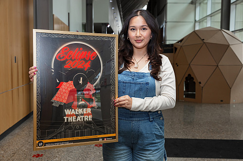 Ines Galindo holds her eclipse poster design. She is a student with the Herron School of Art and Design and created a poster for the ecli...