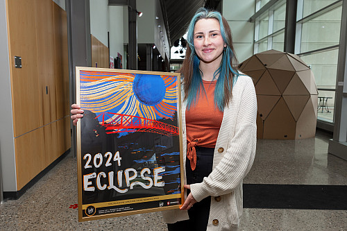 Marissa Eckert holds her eclipse poster design. She is a student with the Herron School of Art and Design and created a poster for the ec...