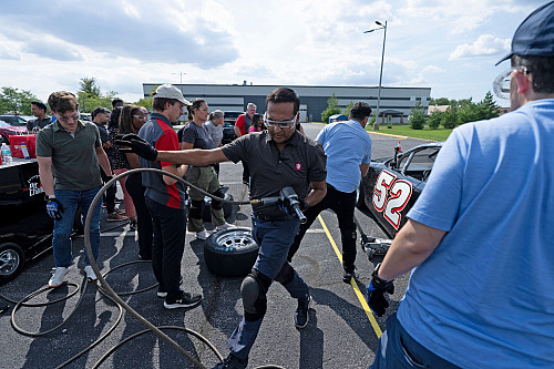 A man carries tools on a race track