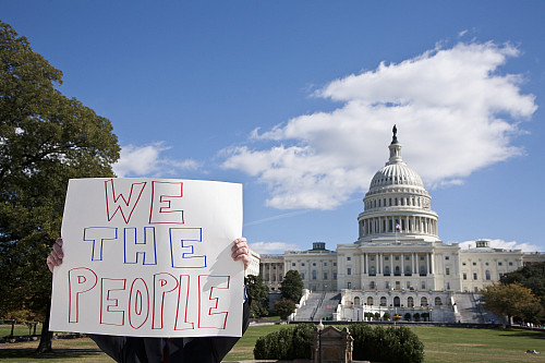 A protestor holding a placard in front of the US Capitol Building