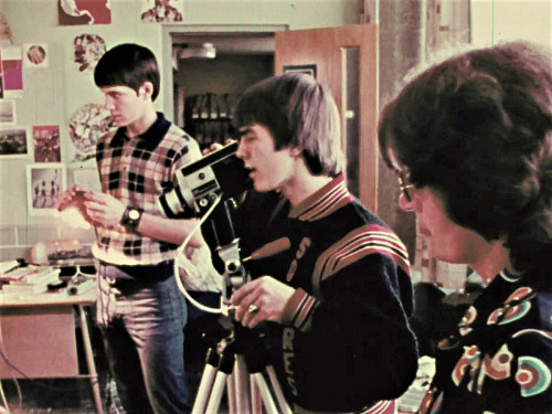 A student looks through the viewfinder on a camera.