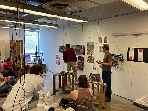 Co-instructor David Ondrik and AI in the Studio students critique works they created during the course. Photo courtesy of Caleb Weintraub