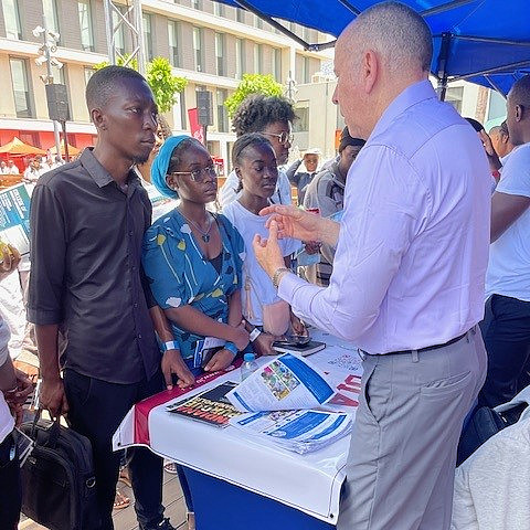 Roberto Swazo talks to Angolan students at an information table. 