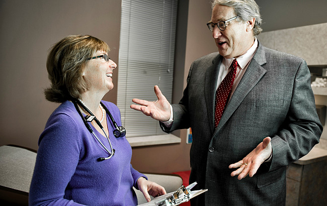 A physician speaks with a professor