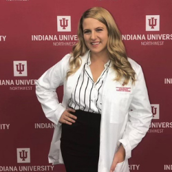 A woman in a nursing uniform smiles.