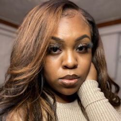 A woman poses while holding her face.