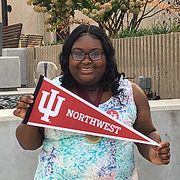 A woman hold a pennant flag while smiling.
