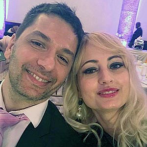 A male and female couple sits smiling at a camera.