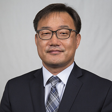 A man in a suit smiles.