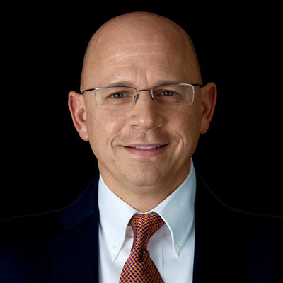Professional photo of a man in a suit smiling.