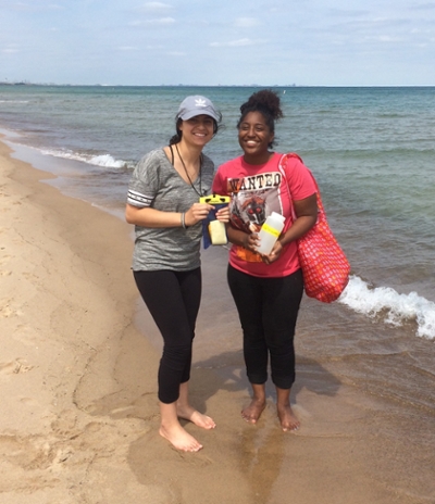 Two people stand on a beach.