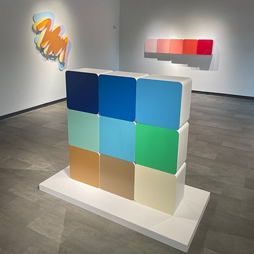 An art gallery featuring nine squares with different colors on them.