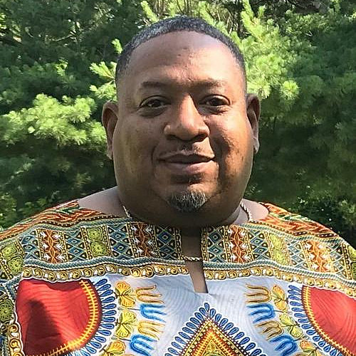 A man in a festive robe smiles.