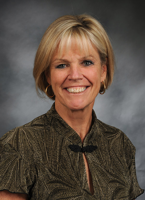 A woman poses and smiles for a photo.