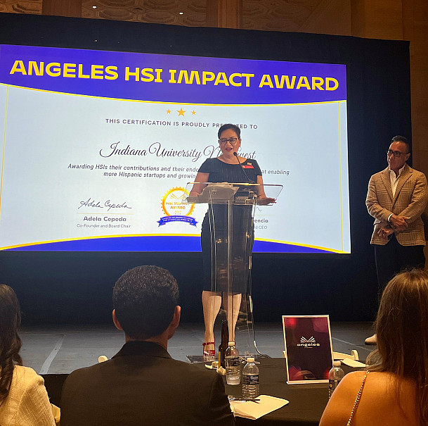A woman standing on stage giving a speech.