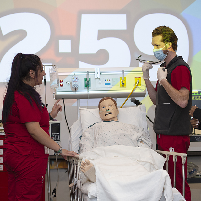 Two nursing students work on a fake patient during Nursing SimWars.