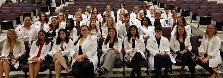A group of nursing graduates smile for a photo.
