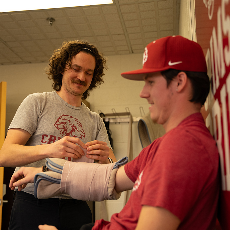 Tim Lapping wrapping student athlete's arm
