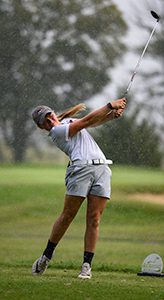 Golfer after taking a swing, arms and golf club raised
