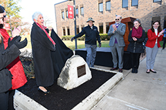 IU East faculty and community celebrating new bicentennial marker. The marker is a rounded triangle shape with a black plaque