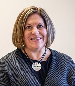 Denise Frazier smiling over a neutral background