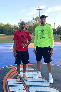 Jaylen McKay wearing a red t-shirt with Julian Short in a neon green shirt, standing in the middle of an outdoor basketball court