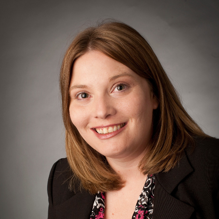 Stephanie Whitehead smiling in front of a neutral background.