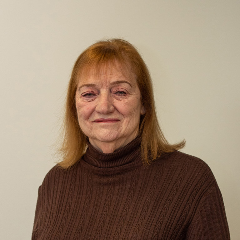 Joan Lafuze smiling in front of neutral background