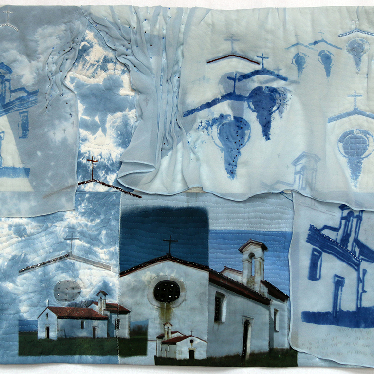 a fiber quilt art piece that includes blue, white, churches and grape vines
