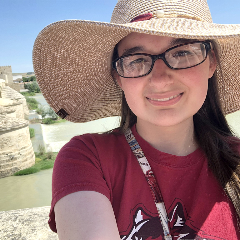 Hannah Buehner smiling at camera on a sunny day in her IU East Red Wolves t-shirt