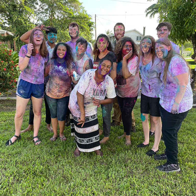 Group of IU East students covered in colorful powder from celebrating Holi, the Hindu (Indian) Festival of Colors in Guyana.