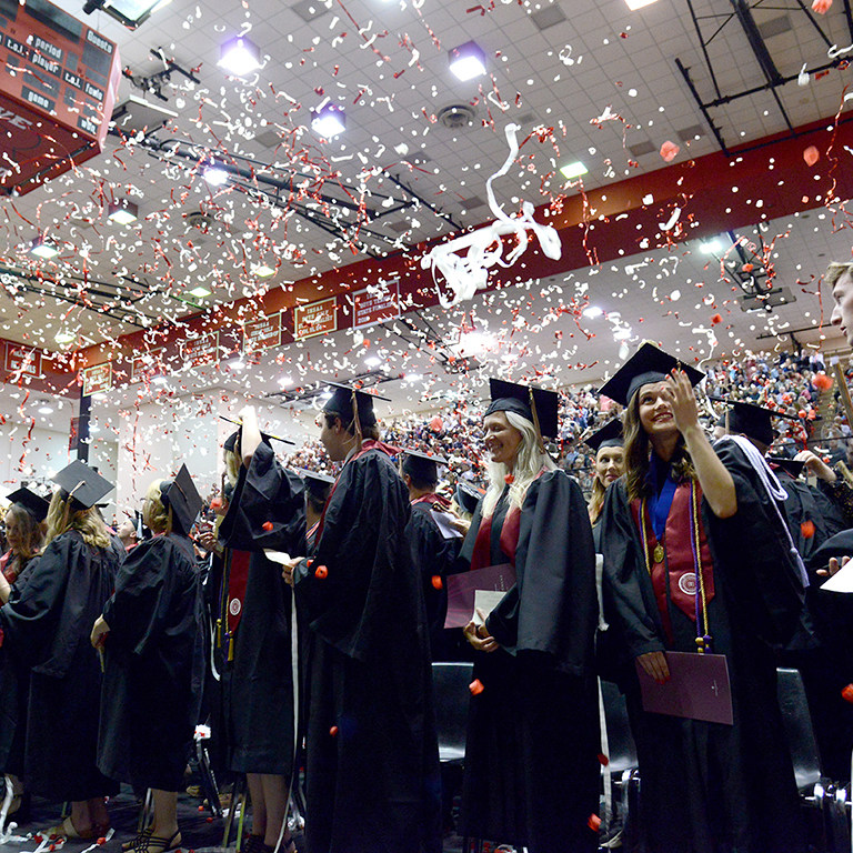 IU East graduates celebrating through a rain of confetti at their Commencement Ceremony in the Richmond High School Tiernan Center
