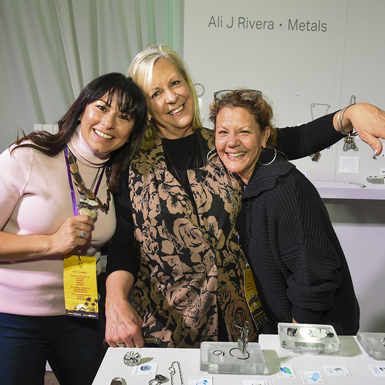 Three women leaning together to pose for a photograph