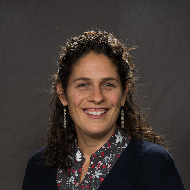 Close-up of Beth Trammell smiling in front of a dark gray background