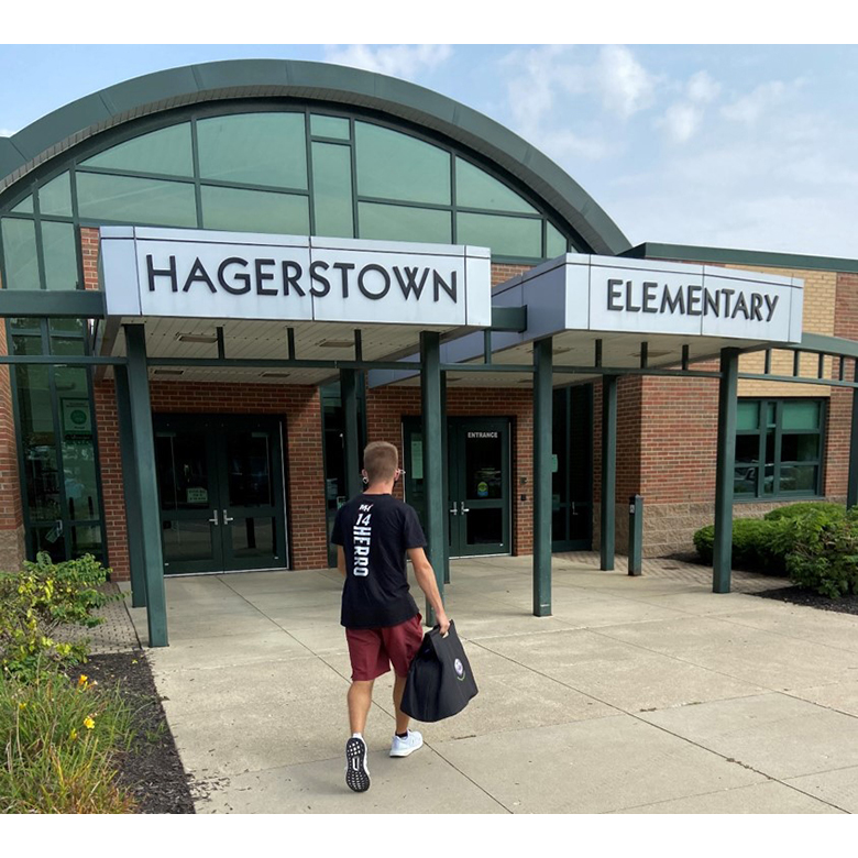Carter Cook carrying a bag as he approaches the entrance to Hagerstown Elementary School
