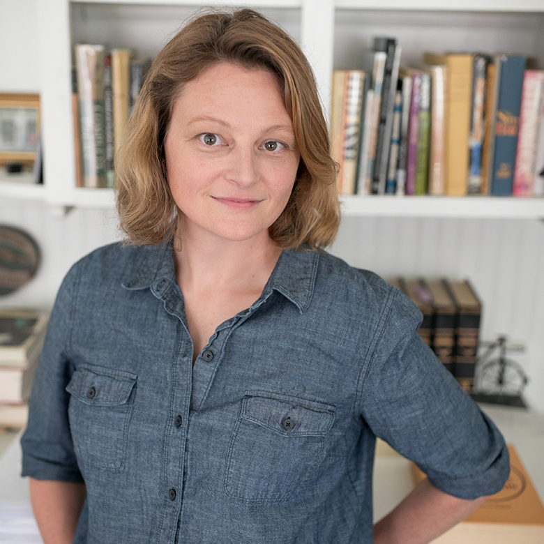 Jessica Anthony smiling in front of a bookshelf.